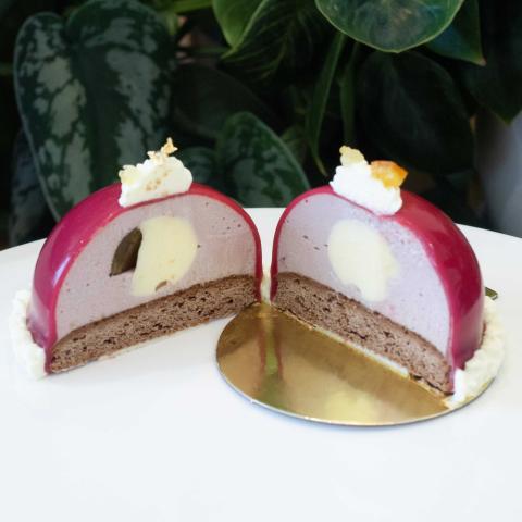 The inside of a petit gateau in two halves showing gingerbread base, mulled wine mousse and orange centres peel
