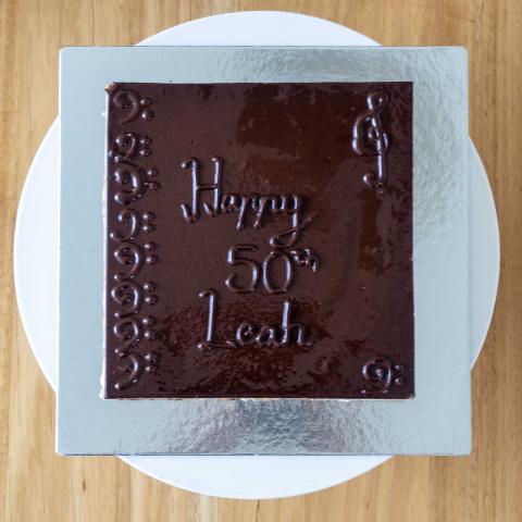A top view of an opera cake with 'happy birthday' written on top